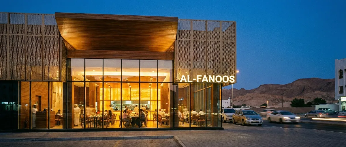 Restaurant exterior and interior design visible from street level in Muscat at evening